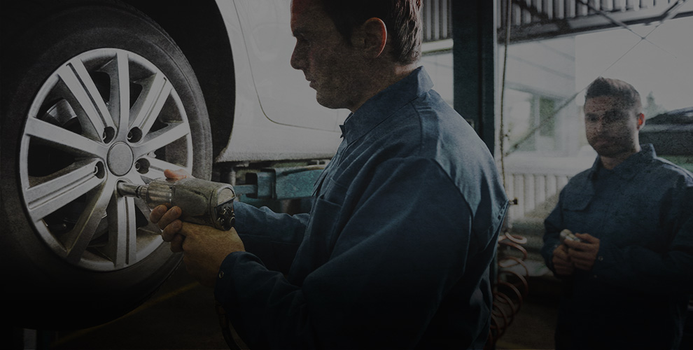 mechaninc fitting new wheel to car on ramp - Tyres Bathgate, West Lothian