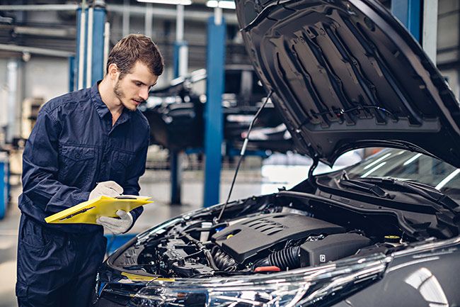Mechanic looking over a vehicle with its bonnet open - Car Servicing Bathgate, West Lothian